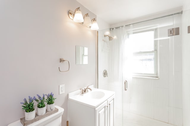 bathroom with walk in shower, vanity, plenty of natural light, and toilet