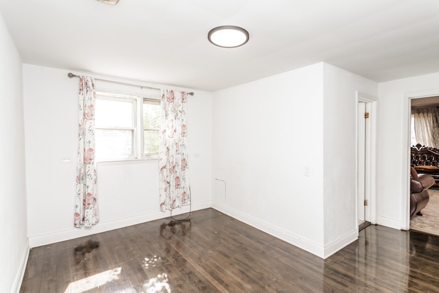 unfurnished room with dark wood-type flooring