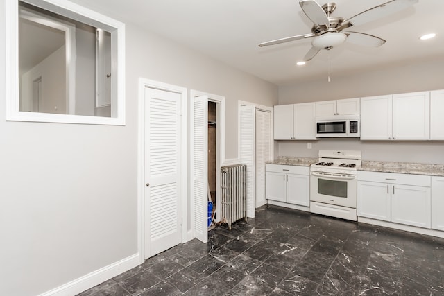 kitchen with ceiling fan, white cabinets, light stone countertops, and white appliances