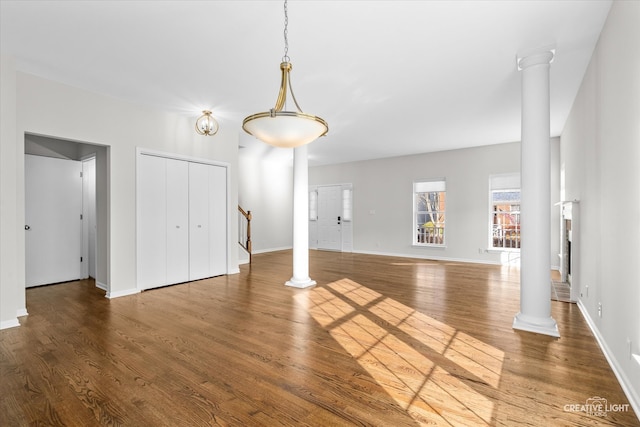 unfurnished living room with hardwood / wood-style floors and decorative columns