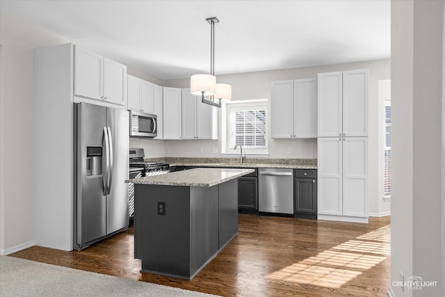 kitchen with a center island, white cabinetry, stainless steel appliances, and dark wood-type flooring