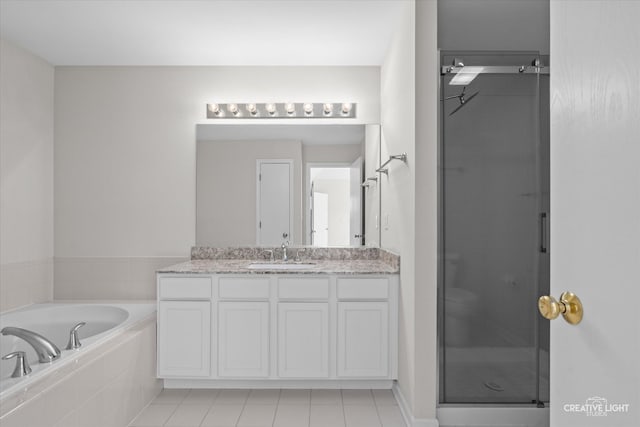 bathroom with tile patterned flooring, vanity, and plus walk in shower