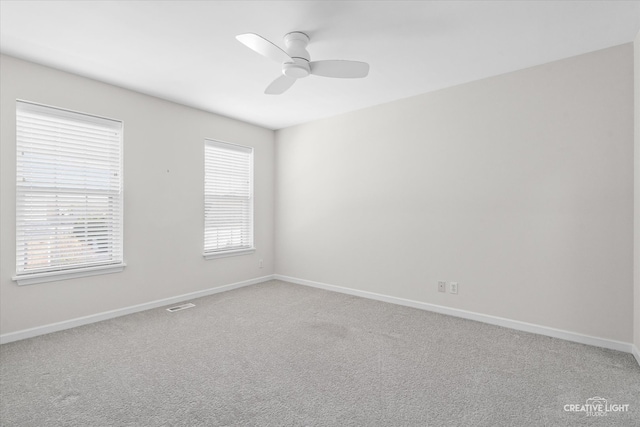 carpeted spare room with ceiling fan