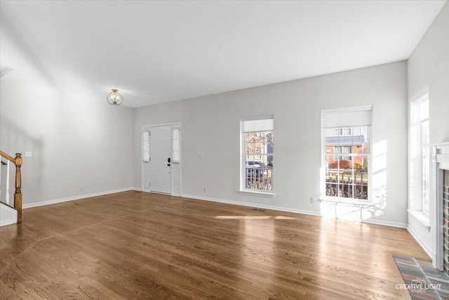 unfurnished living room featuring hardwood / wood-style flooring and a fireplace