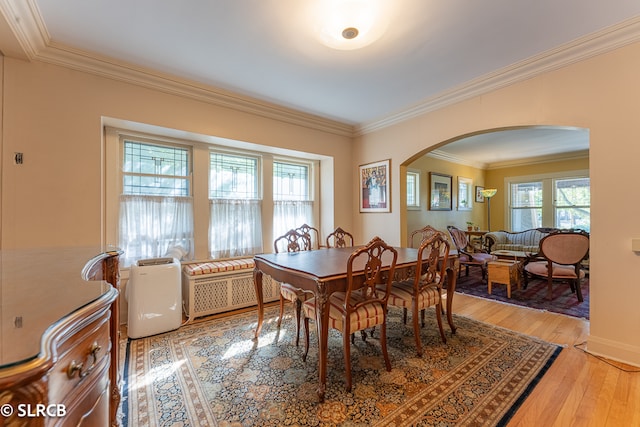 dining room with ornamental molding and light wood-type flooring