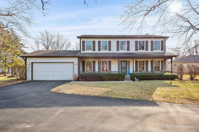 view of front of home with a garage, covered porch, and a front lawn