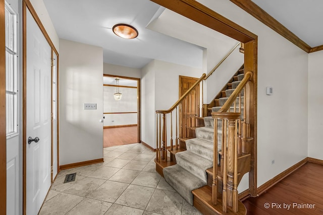 tiled entrance foyer featuring ornamental molding