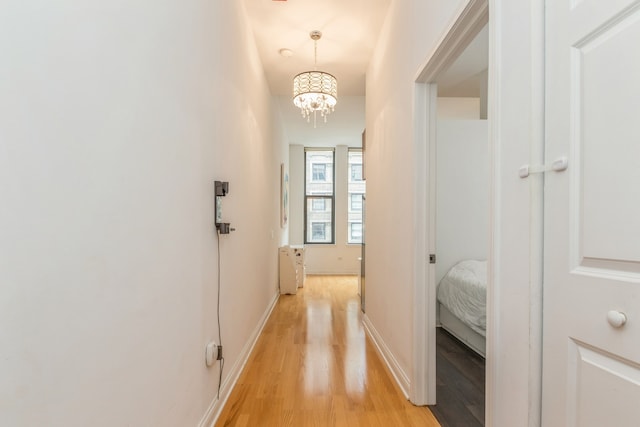 corridor featuring light hardwood / wood-style floors and a chandelier