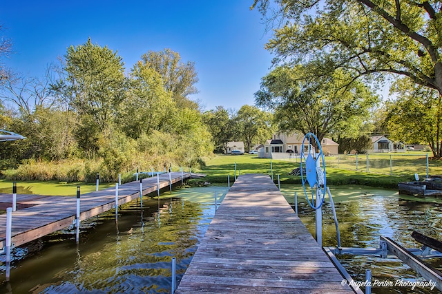 view of dock featuring a yard and a water view