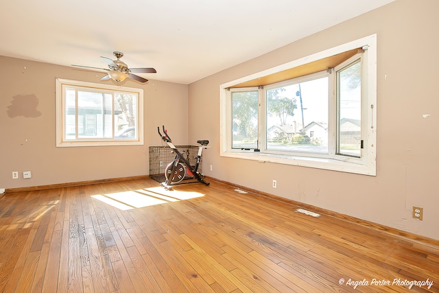 empty room featuring plenty of natural light, light wood-type flooring, and ceiling fan