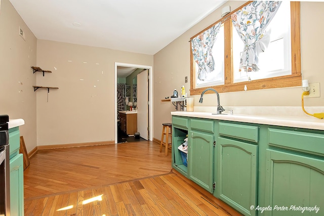 3012 Oakwood Ave, Mchenry, IL 60051 - kitchen featuring visible vents, light countertops, a sink, light wood finished floors, and green cabinetry
