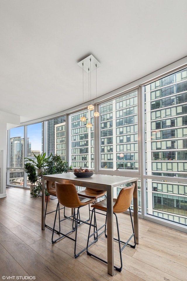 dining room featuring a chandelier, hardwood / wood-style flooring, and floor to ceiling windows