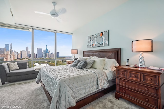 bedroom with expansive windows, ceiling fan, and light carpet