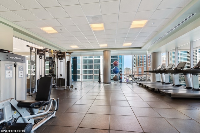 gym with a drop ceiling and floor to ceiling windows