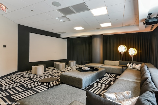 carpeted home theater room with a paneled ceiling