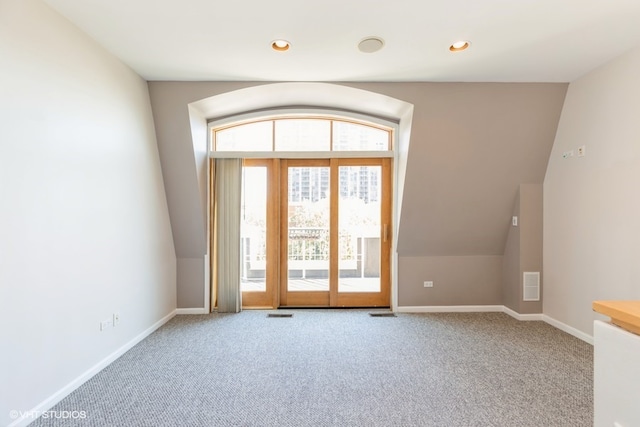 interior space featuring lofted ceiling, a wealth of natural light, and carpet flooring