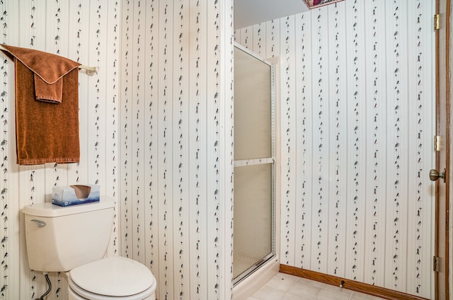 bathroom with an enclosed shower, tile patterned floors, and toilet