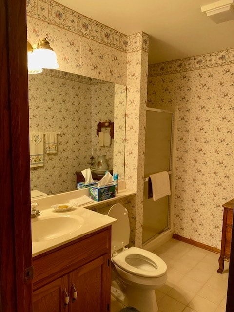 bathroom with vanity, tile patterned flooring, toilet, and a shower with door