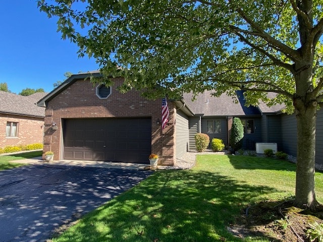 ranch-style home featuring a garage and a front lawn