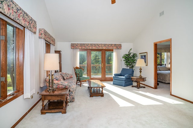 carpeted living room with high vaulted ceiling and a wealth of natural light