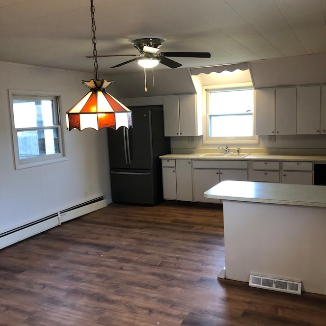 kitchen with white cabinetry, black refrigerator, plenty of natural light, and dark hardwood / wood-style flooring