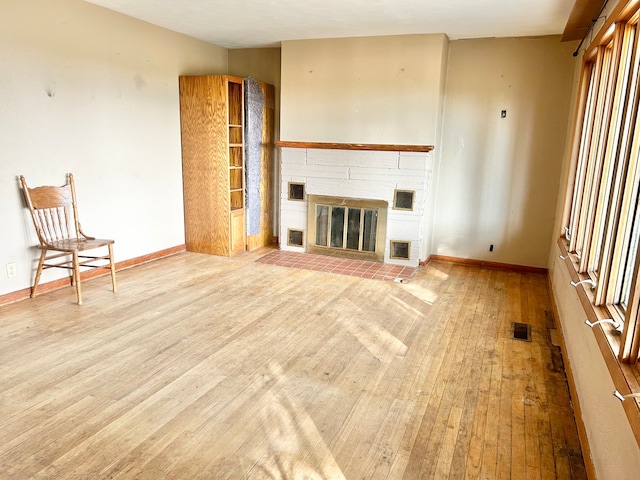 unfurnished living room with light wood-type flooring and a fireplace