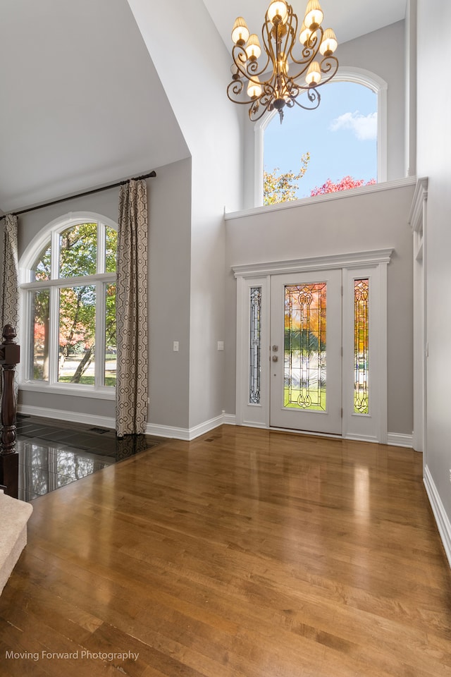 entrance foyer featuring an inviting chandelier, hardwood / wood-style flooring, and plenty of natural light