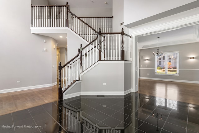 staircase with hardwood / wood-style floors and an inviting chandelier