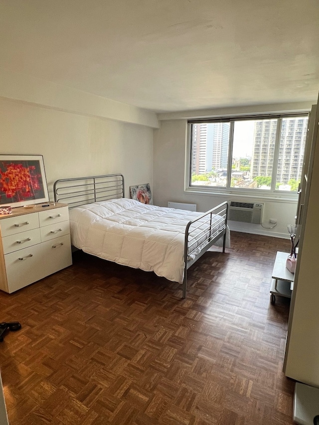 bedroom featuring dark parquet floors and a wall unit AC