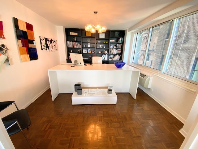 home office with dark parquet floors, built in desk, an inviting chandelier, and a wall unit AC