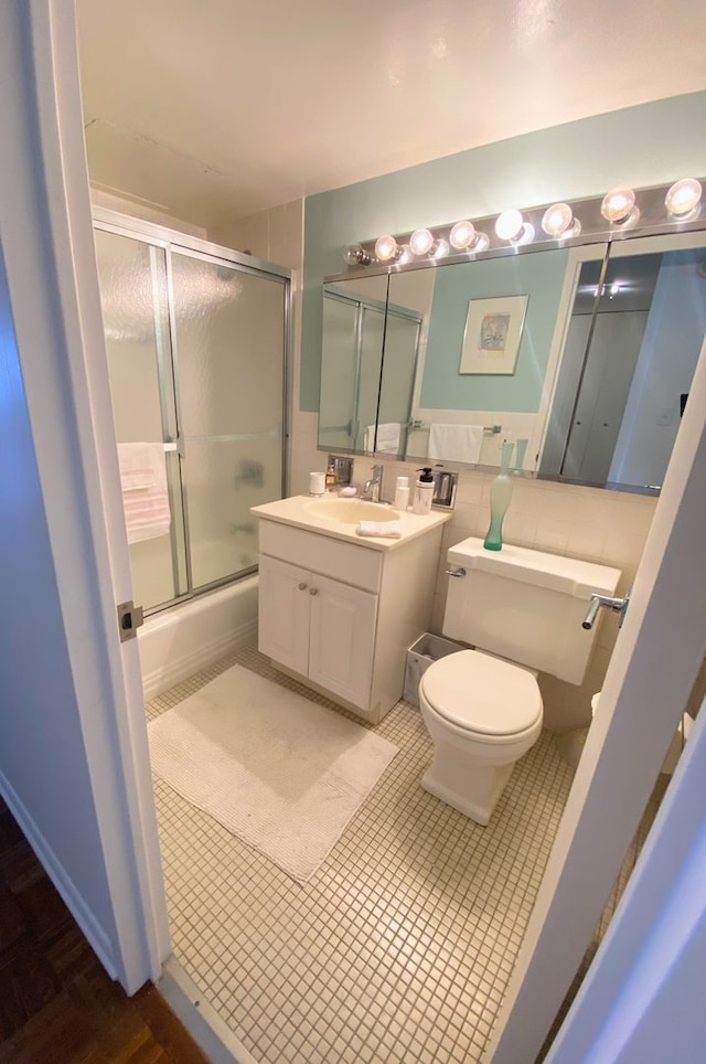 full bathroom featuring shower / bath combination with glass door, vanity, and toilet