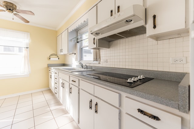 kitchen with black electric cooktop, plenty of natural light, backsplash, and white cabinets