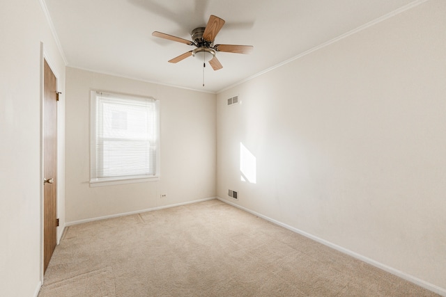 carpeted empty room with ceiling fan and ornamental molding