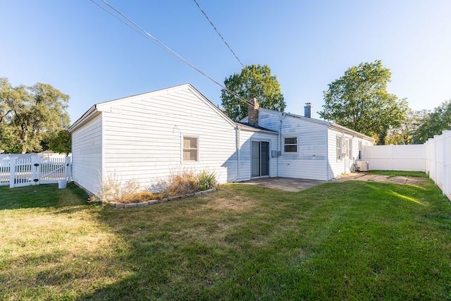 rear view of property with a yard and a patio area