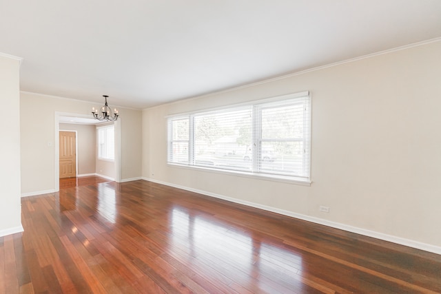 unfurnished room with dark hardwood / wood-style floors, crown molding, and an inviting chandelier