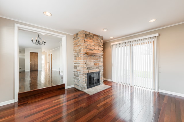 unfurnished living room featuring a fireplace, an inviting chandelier, crown molding, and dark hardwood / wood-style flooring