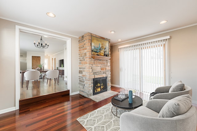 living room with ornamental molding, a fireplace, a chandelier, and dark hardwood / wood-style flooring