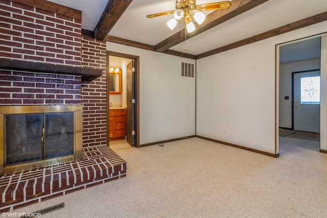 living room with a fireplace, beam ceiling, and light colored carpet