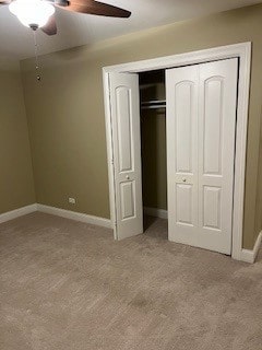 unfurnished bedroom with light carpet, a closet, and ceiling fan