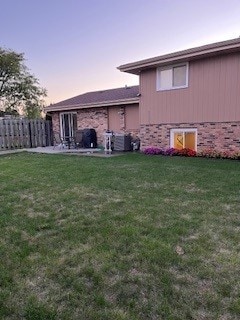 back house at dusk featuring a yard