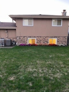 view of property exterior with a yard and central air condition unit