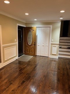 entryway with ornamental molding and dark hardwood / wood-style floors