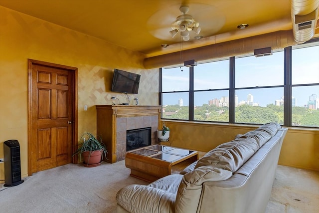 carpeted living room featuring ceiling fan and a tile fireplace