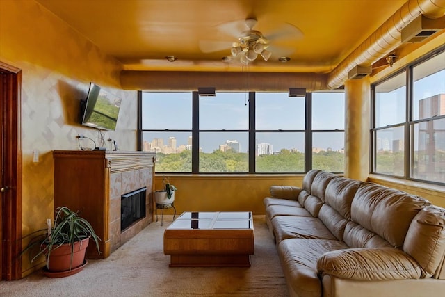 sunroom / solarium with ceiling fan, a tiled fireplace, and plenty of natural light