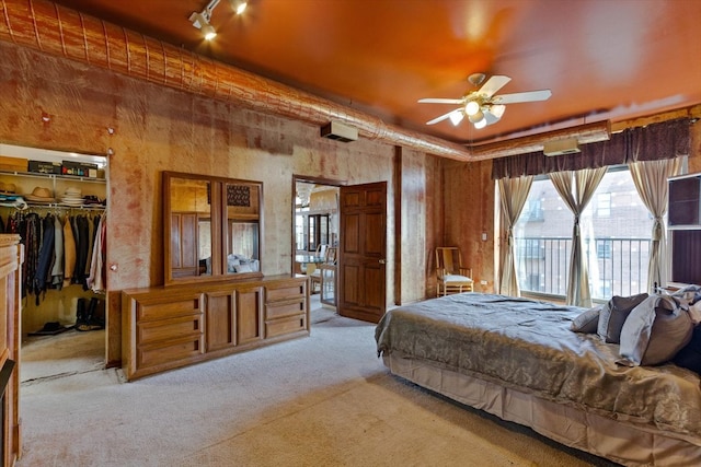 carpeted bedroom featuring ceiling fan, a closet, access to outside, and rail lighting