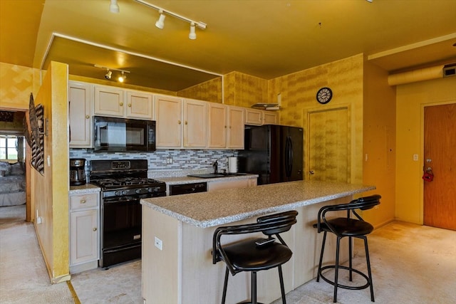 kitchen featuring tasteful backsplash, light colored carpet, a kitchen island, black appliances, and a kitchen bar