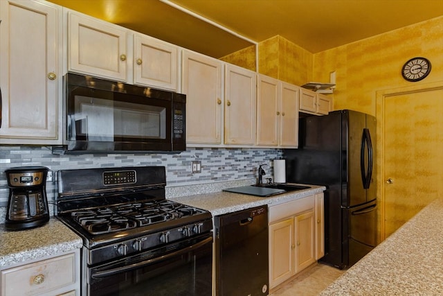 kitchen featuring black appliances, sink, and tasteful backsplash