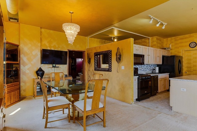 dining space with light carpet, an inviting chandelier, and rail lighting