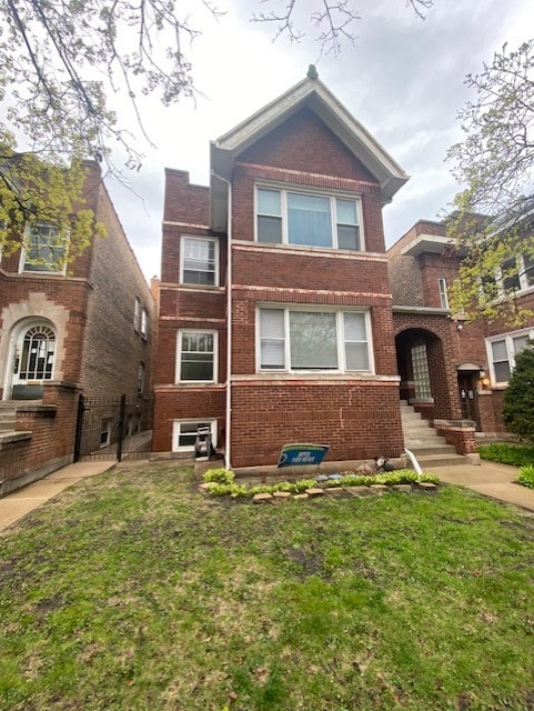 view of front of home featuring brick siding and a front lawn