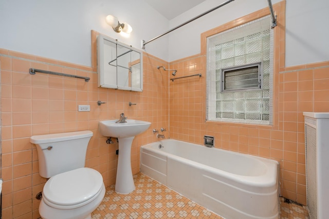 bathroom with tiled shower / bath combo, tile walls, tile patterned floors, and toilet